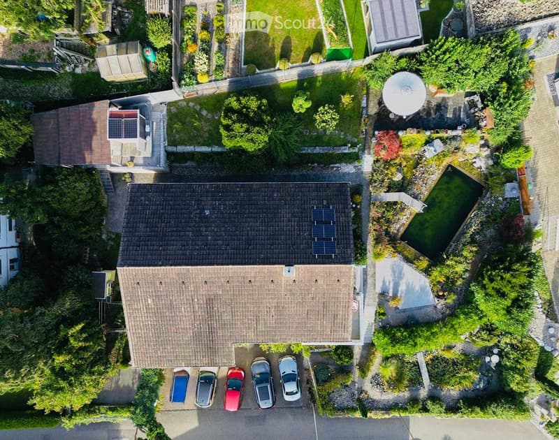 House with solar panels on the roof, swimming pool, 4 cars parked in front