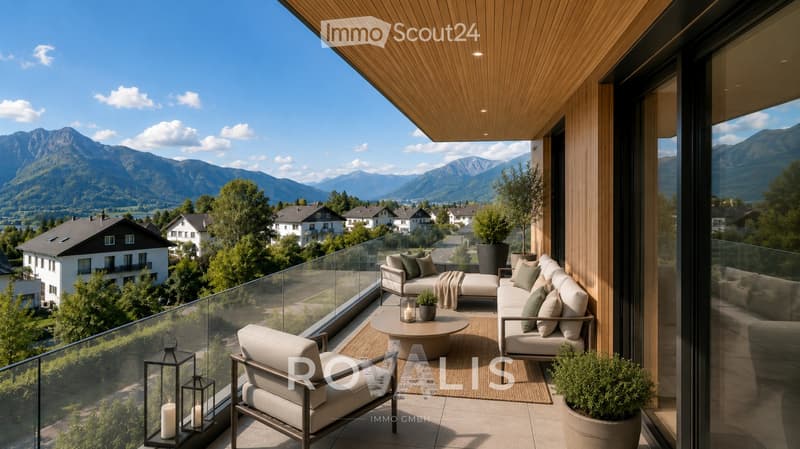 Modern balcony with wooden ceiling, glass railing, and scenic mountain view. Features a sofa, coffee table, armchair, lantern, and potted plants.
