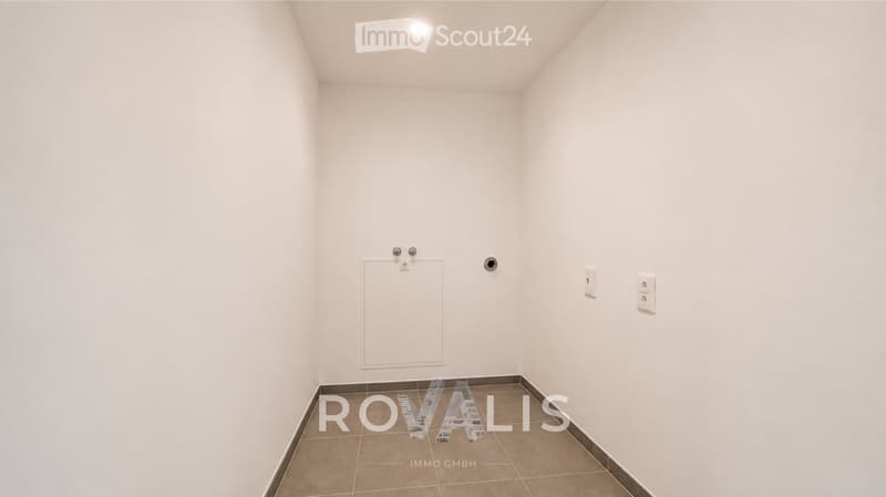 Empty room with white walls, tiled floor, and basic electrical outlets. No furniture or equipment present.