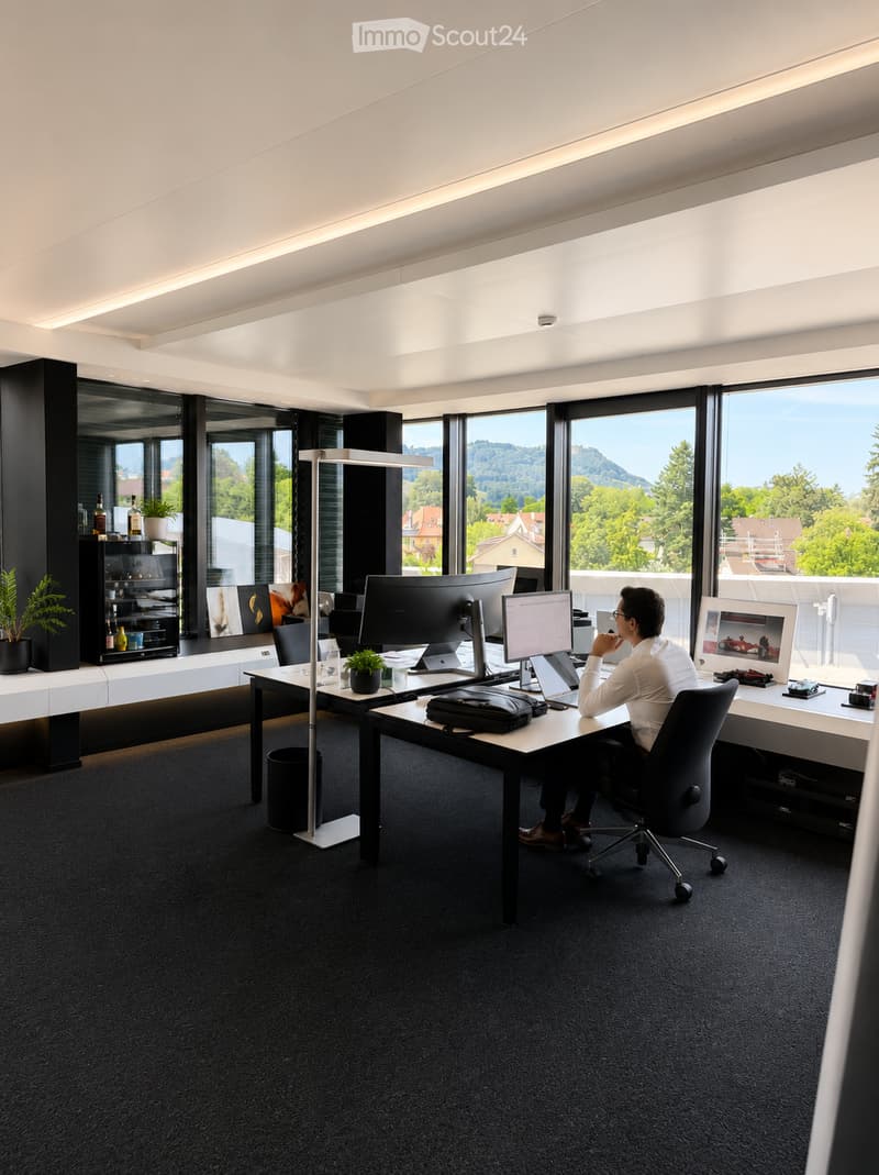 Modern office space with large windows, a desk with multiple monitors, a laptop, and a comfortable chair. The room features a sleek design with a black carpet, white walls, and a view of greenery outside.