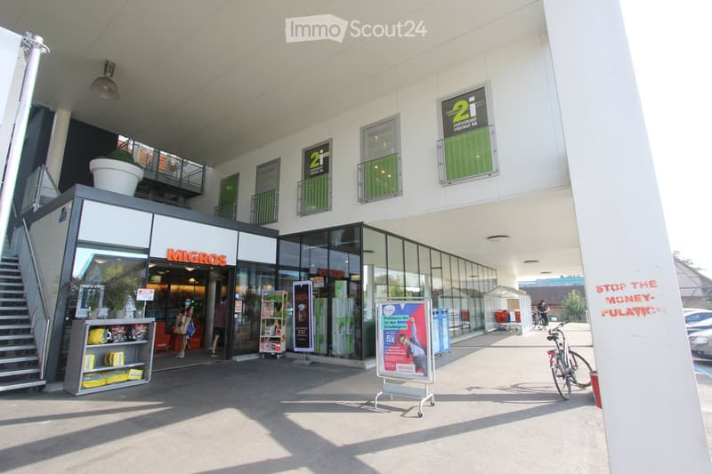 Shop exterior, covered entrance, stairs, bicycles parked, signboards, potted plants