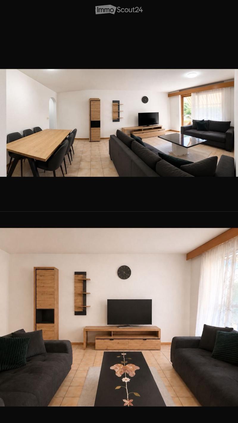 Modern living and dining area with dark grey sofas, a coffee table, a TV, a dining table with chairs, and wooden cabinets.