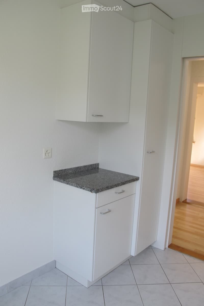 white cabinets, granite countertop, white tiled floor, power outlet