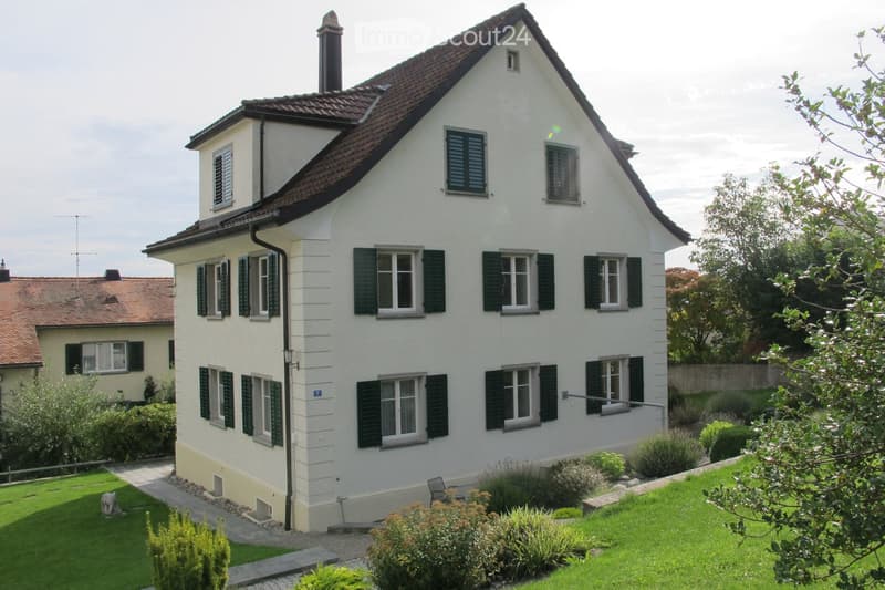 3 story house, white exterior, brown roof, green shutters, garden, pathway