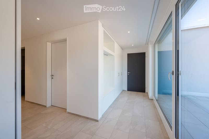 empty hallway, light wood flooring, white walls, 2 doors, sliding glass door