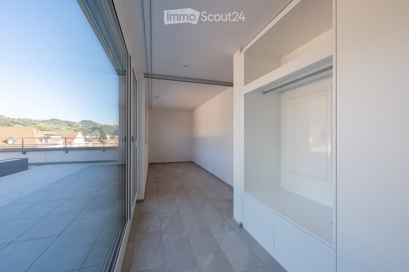 empty room with floor tiles, large glass door, glass window, built-in wardrobe, and large balcony