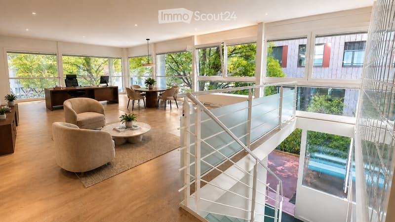 Modern, open-concept living and dining area with large windows, light wood flooring, and contemporary furniture including a sofa, coffee table, dining table, and desk.