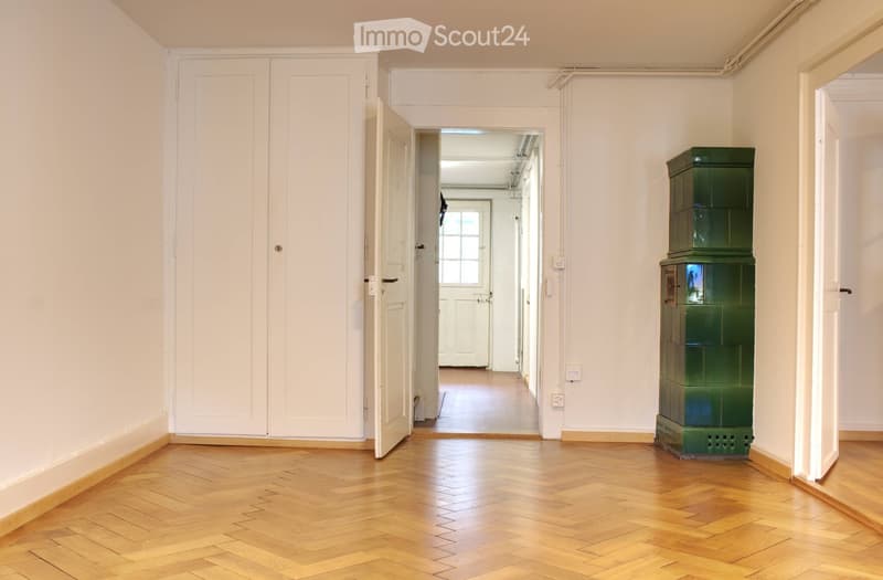 empty room, wooden parquet floor, white walls, open door, fireplace