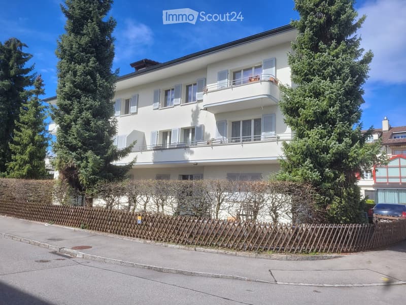 white exterior with windows, balcony on first floor, wooden fence