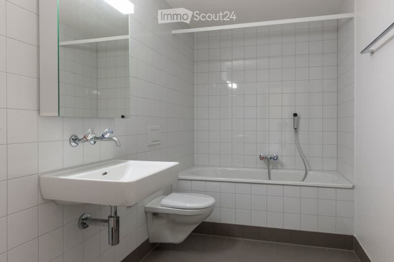 white bathtub, white sink, white toilet, white tiled walls, white tiled floor