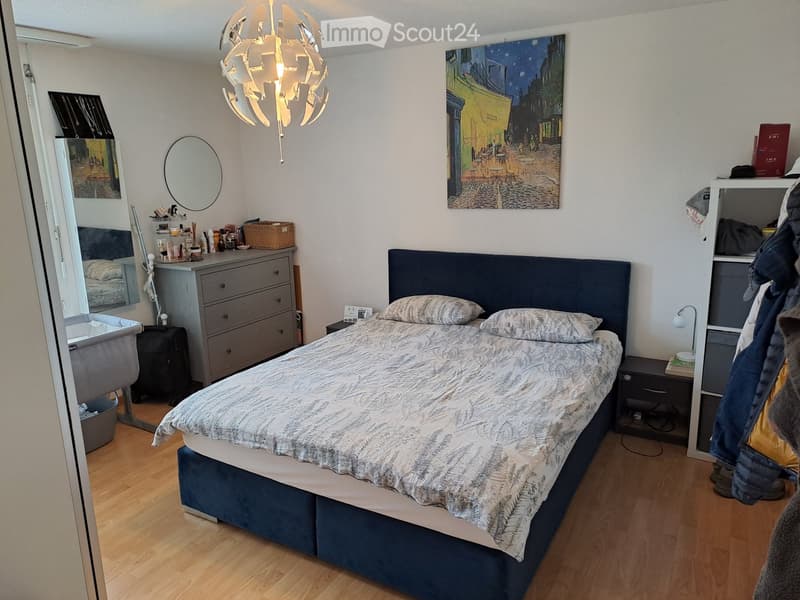 Bedroom with bed, nightstands, dresser, mirror, painting, chandelier, and various items on dresser