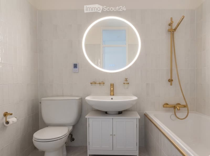 Modern bathroom with white tiles, a floating sink cabinet, a round LED mirror, a bathtub with a gold showerhead, and a toilet.