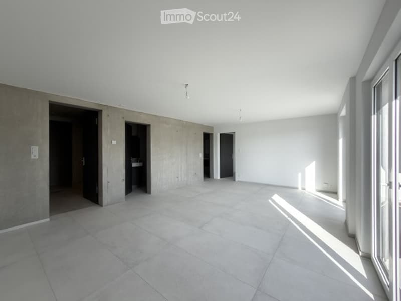 Empty room with white walls, tiled floor, and several open doorways leading to other spaces.