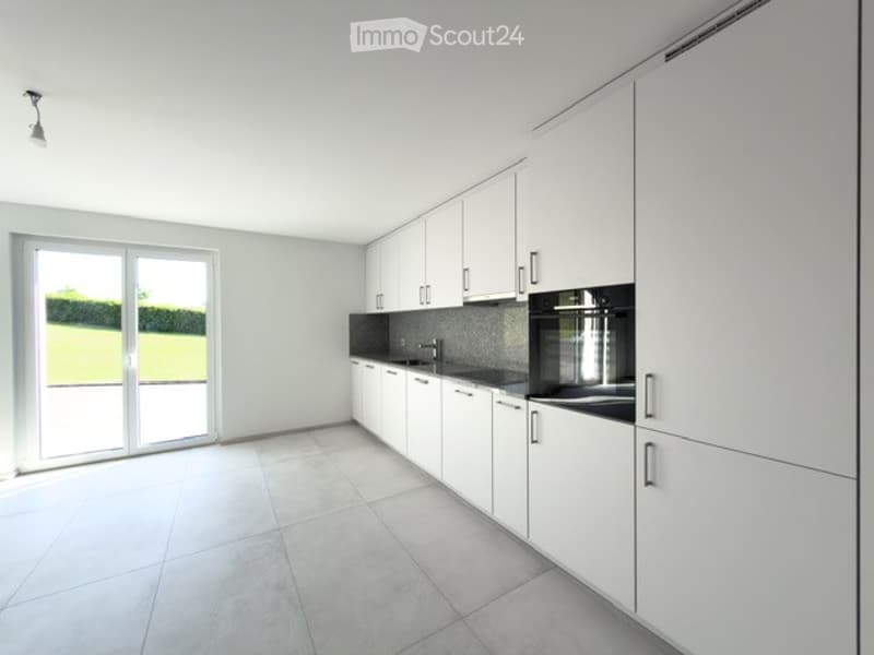 Modern, minimalist kitchen with white cabinets, a central island, and a large sliding glass door leading to a garden.