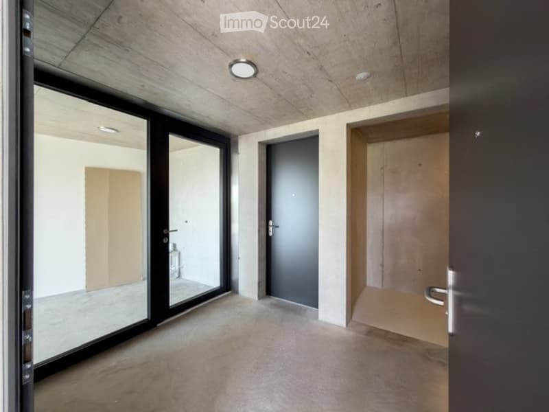 Empty room with large glass sliding doors, concrete floor, and recessed lighting. No furniture or equipment visible.