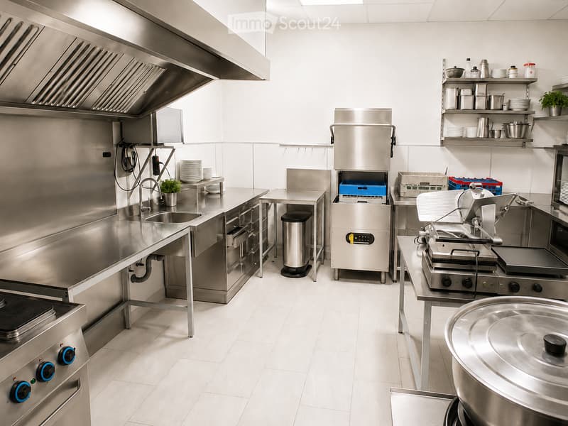 Commercial kitchen with stainless steel appliances, including a sink, oven, refrigerator, microwave, grill, and various cooking equipment. Shelves hold plates, pots, and pans.