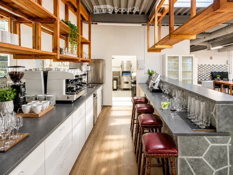 Modern kitchen with wooden beams, stainless steel appliances, and a central island with bar stools.
