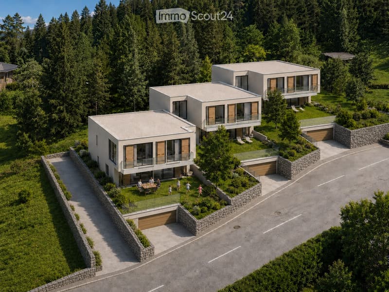 Aerial view of a modern, multi-level house with large windows and balconies, surrounded by a landscaped garden and parking area.