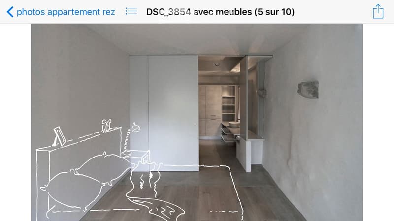 Modern, minimalist room with a large sliding wardrobe, a small bathroom area with a sink and mirror, and a clean, contemporary design.
