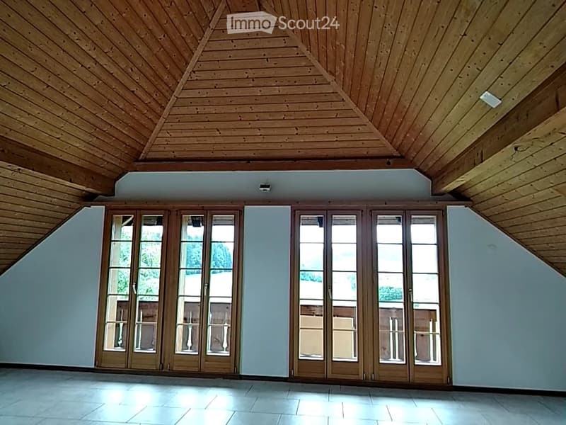 Bright, empty room with wooden ceiling, large glass doors, and tiled floor. No furniture or equipment present.