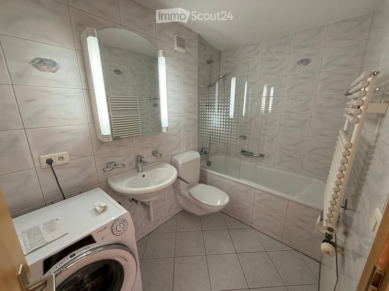 tiled walls and floor, shower, sink, toilet, bathtub, mirror, washing machine, towel rack
