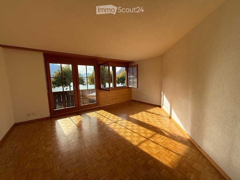 empty room, hardwood floor, large glass doors to balcony, view of lake and mountains