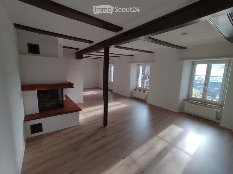 empty room, wooden floor, wooden beams, fireplace, three windows, radiator