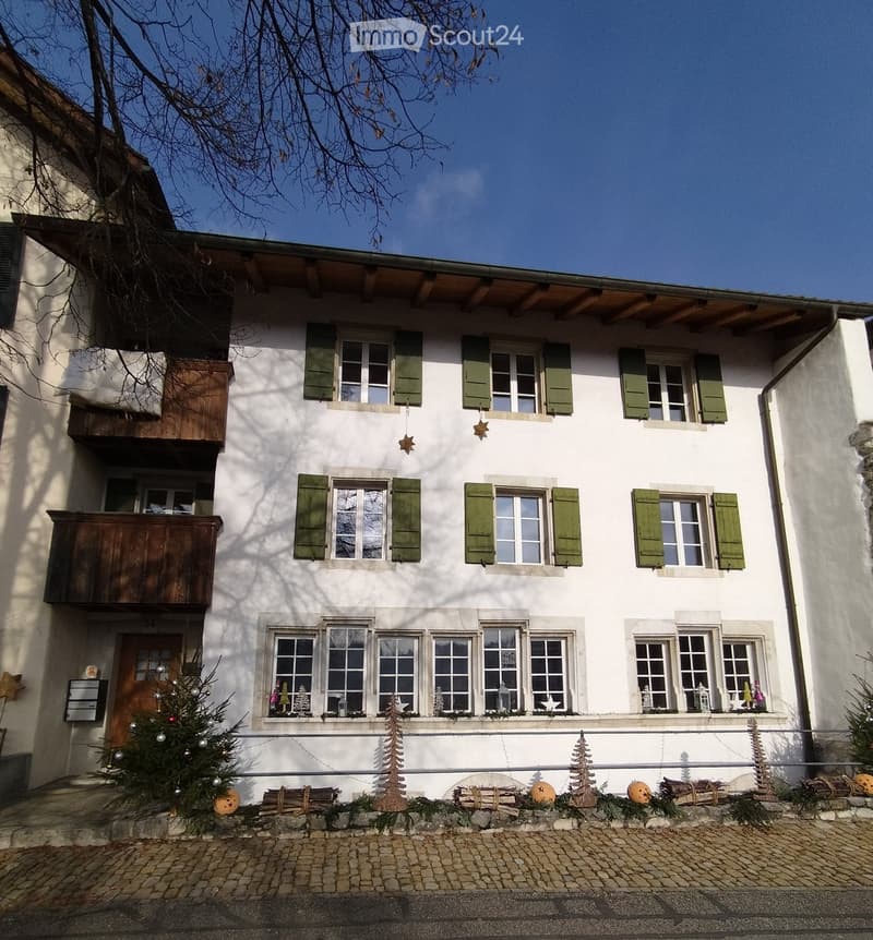3 story house, white painted, green shutters, front door, small porch, multiple windows, stone path, holiday decoration