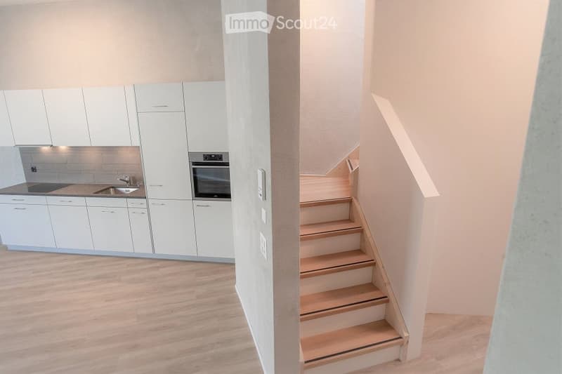 Kitchen with modern appliances, raised ground floor, wooden cabinets, granite countertop, stainless steel sink, and built-in oven.
