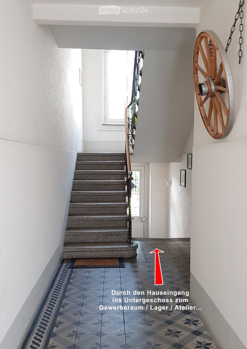 Staircase leading to an upper level, with a decorative wheel on the wall and a patterned tile floor.