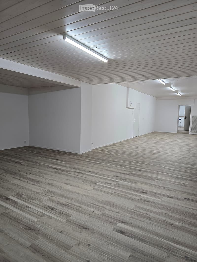 Empty room with wooden flooring, white walls, and a white ceiling with integrated lighting. No furniture or equipment is present.