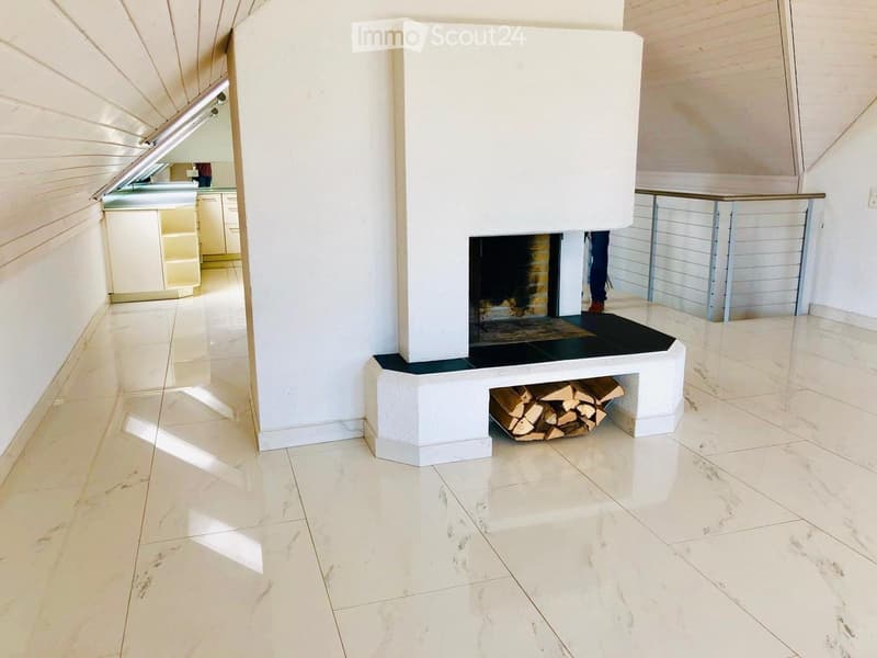Modern living room with a white fireplace, polished tile floor, and a woodpile beneath the fireplace.