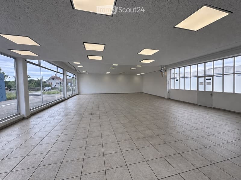 Empty room with tiled floor, large windows, and recessed lighting. No furniture or equipment present.