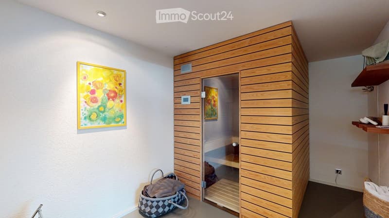 Bathroom with a wooden sauna, shelves, and a colorful painting on the wall.