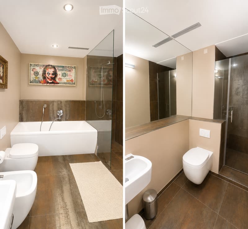 Modern bathroom with a bathtub, toilet, sink, and glass-enclosed shower. Features a dark brown tiled floor, beige walls, and decorative artwork.