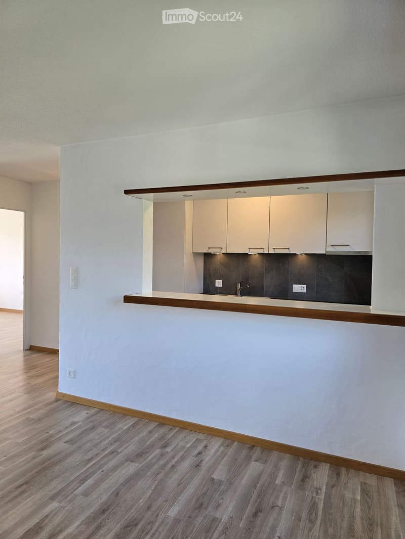 Modern kitchen with light-colored cabinets, a wooden countertop, and a sink with a faucet. The floor is made of light wood.