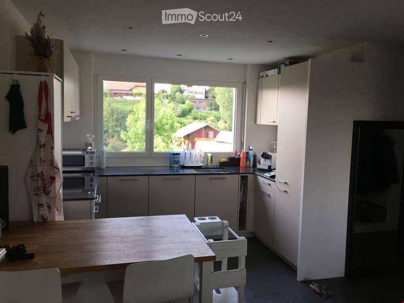 white kitchen cabinets, wooden dining table, sink with faucet, refrigerator, oven, view of house outside