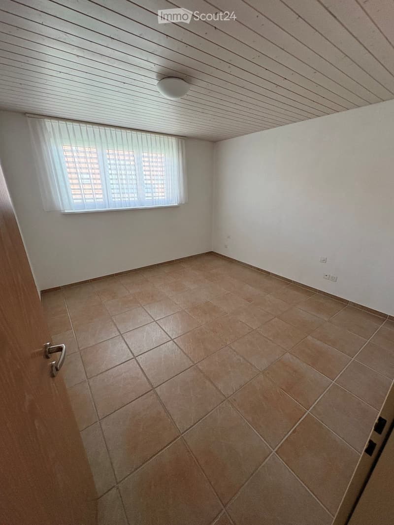 Empty room with tiled floor, white walls, and a window with blinds. No furniture or equipment visible.