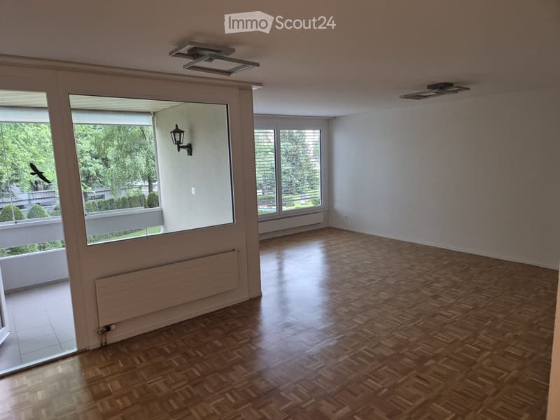 Empty room with wooden parquet flooring, large windows, and modern ceiling lights. No furniture or equipment present.