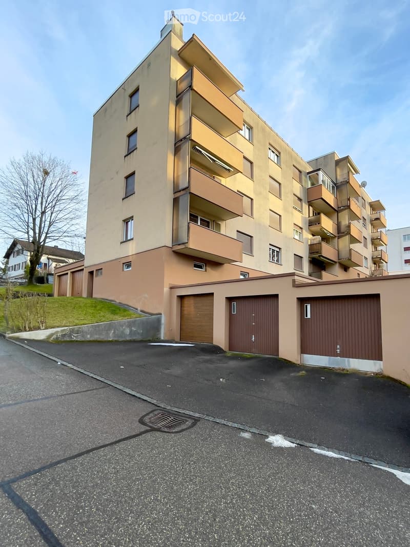 4-story residential building, beige and brown wall, balcony, 3 garages in the front