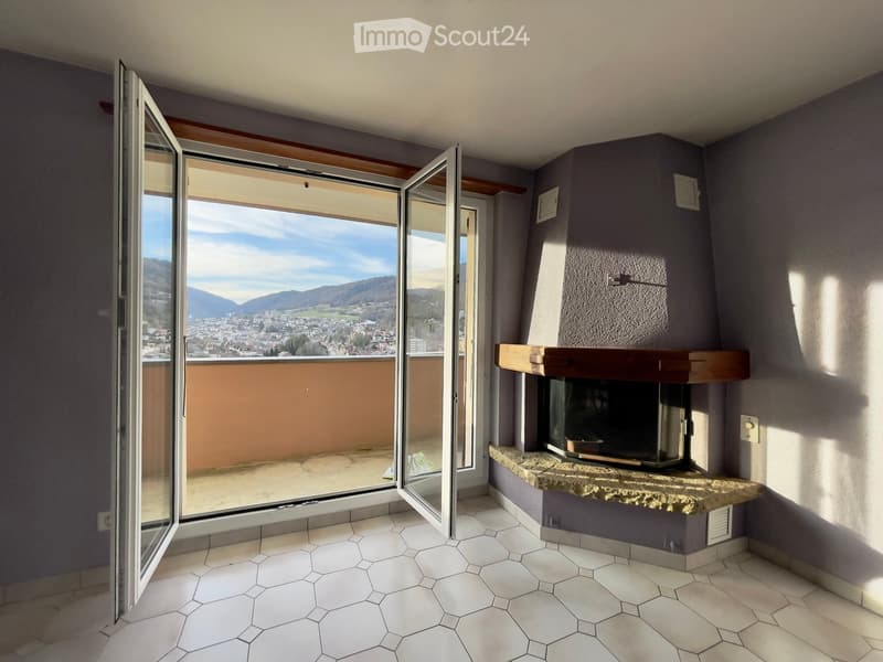 open sliding glass doors leading to balcony, fireplace, panoramic view of mountains, white hexagon tiles