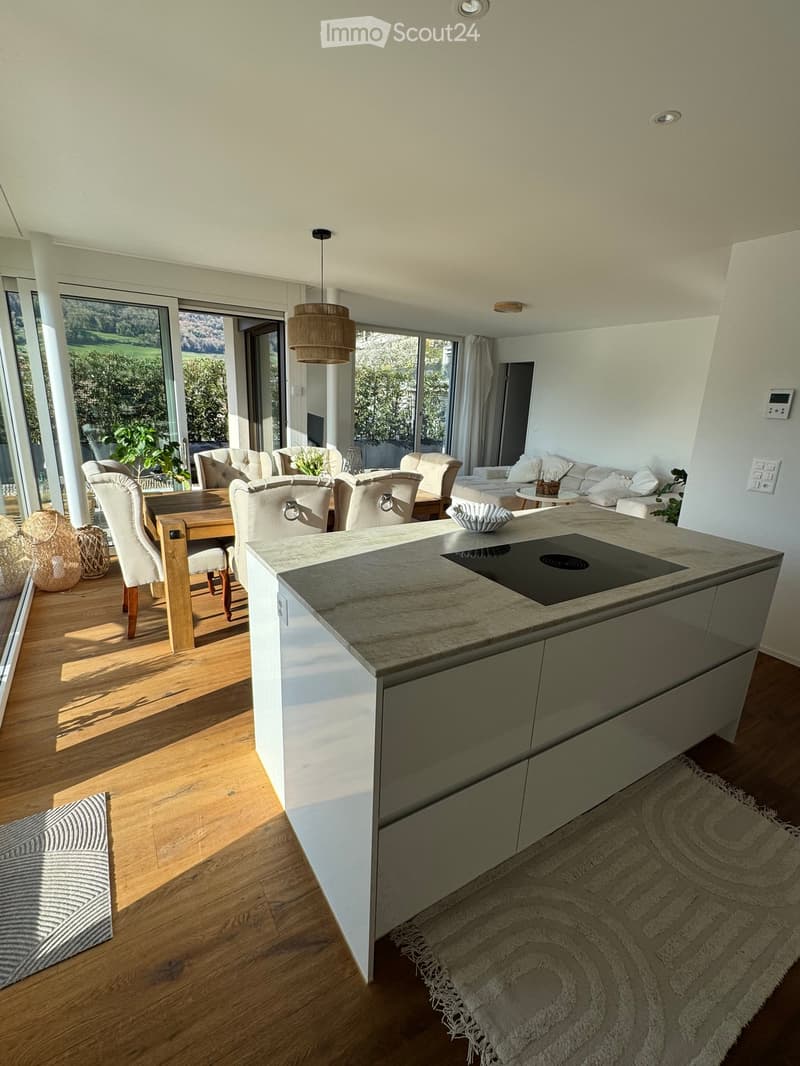 modern kitchen with large island, dining area, large windows, wooden floor, white walls, modern furniture