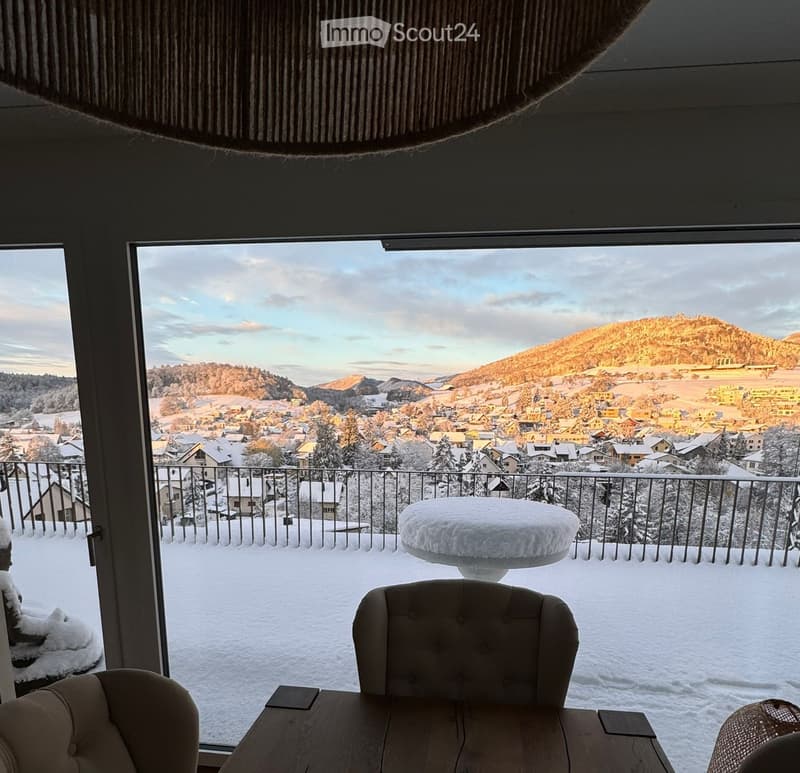large windows, balcony, snow-covered landscape, mountains, dining table, chairs