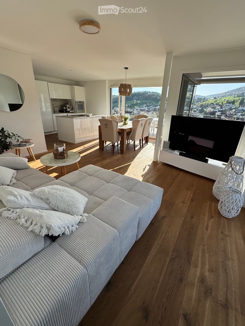 large living room, wooden floor, large windows, dining table, TV, sofa, kitchen
