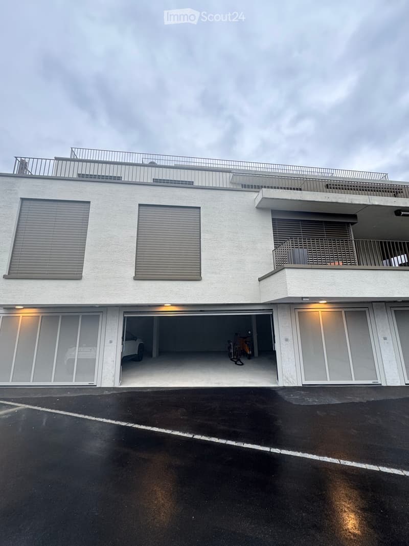 2 story house, white exterior, large windows, balcony, underground garage with access from outside