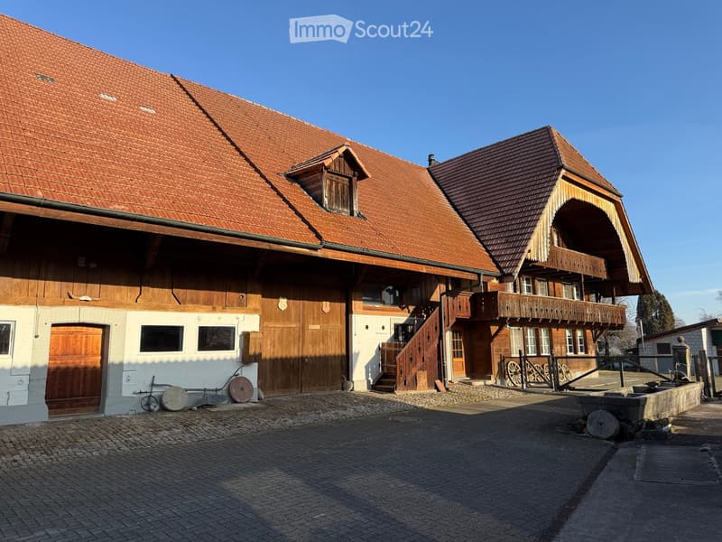 The exterior of a house made of red tiles, wooden beams, wooden doors, glass windows, and stairs.