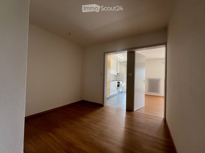 {"visible_features":[],"type":"Apartment","description":"The image shows an empty apartment room with hardwood floors, white walls, and a doorway leading to another room. The room appears to be a living or bedroom space with no visible furniture or decor.