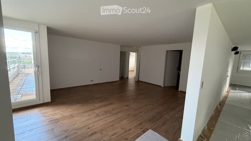 Empty room with wooden flooring, white walls, and large windows. No furniture or equipment present.