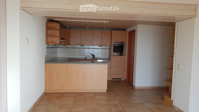 Modern kitchen with light wooden cabinets, stainless steel appliances, tiled backsplash, and granite countertop.