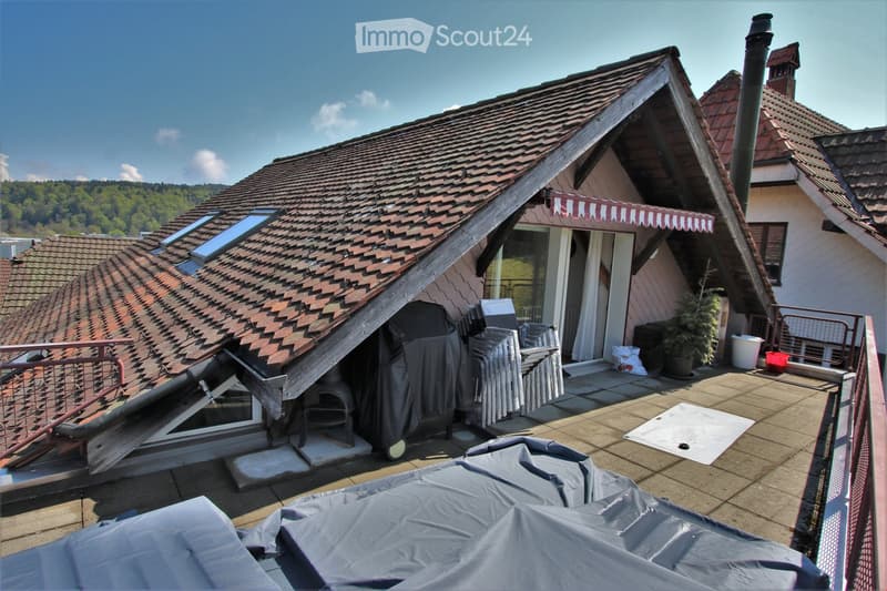 Roof terrace with tiled flooring, covered furniture, and a view of surrounding greenery and hills.